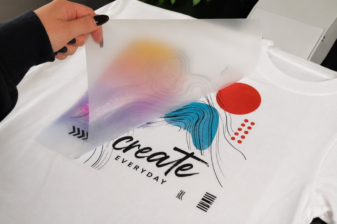 Peeling a pressed DTF transfer off a t-shirt